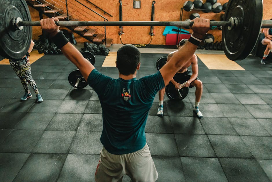 A group of men engaged in a vigorous weightlifting session at a gym